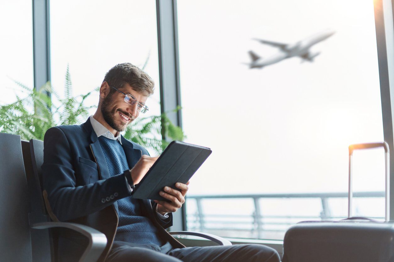 Man on iPad at an airport waiting for his flight